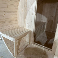 Interior of the barrel sauna showing tiered slatted benches and timber-lined walls