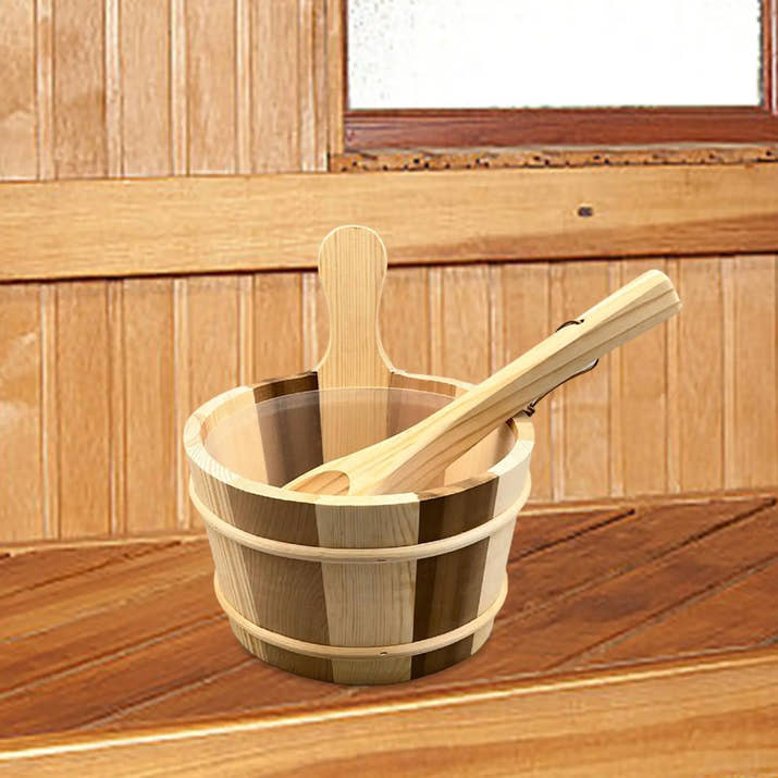 Wooden sauna bucket and ladle on a sauna bench beside a window